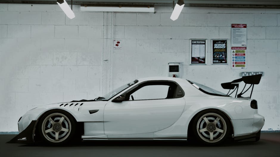 Sleek white Mazda RX-7 parked indoors, captured in a side view.